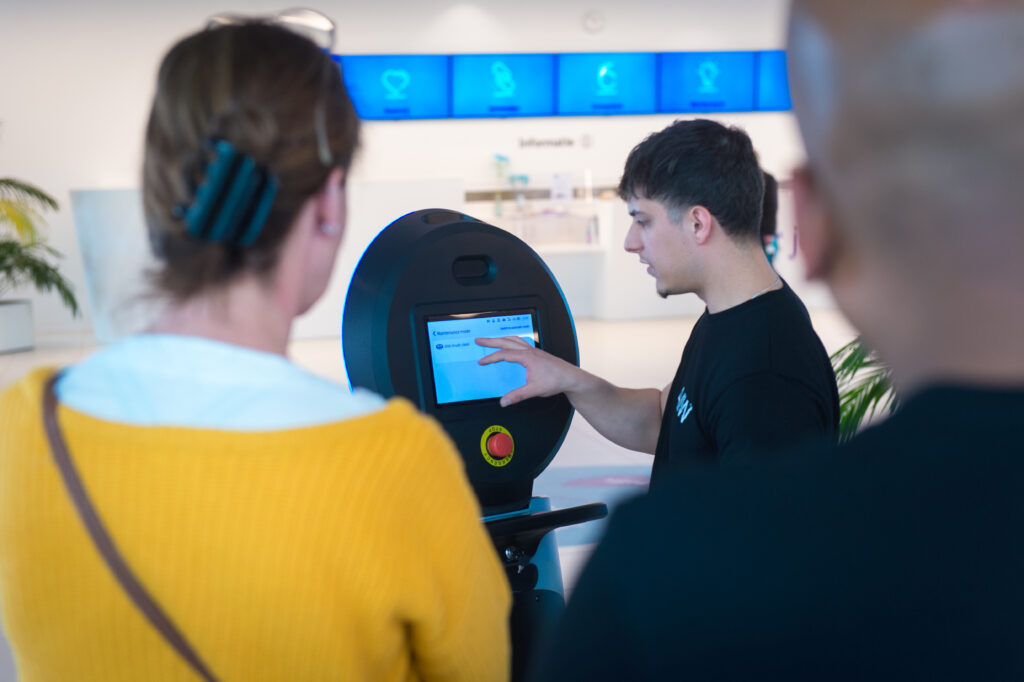 Werknemer toont hoe robot werkt