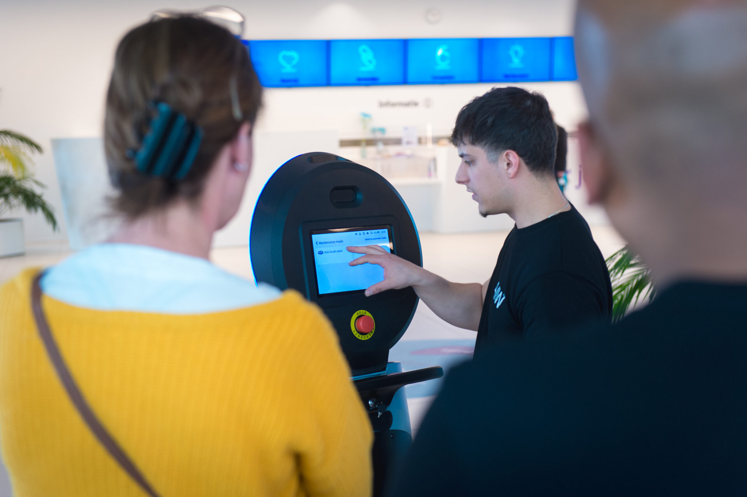 Werknemer toont hoe robot werkt